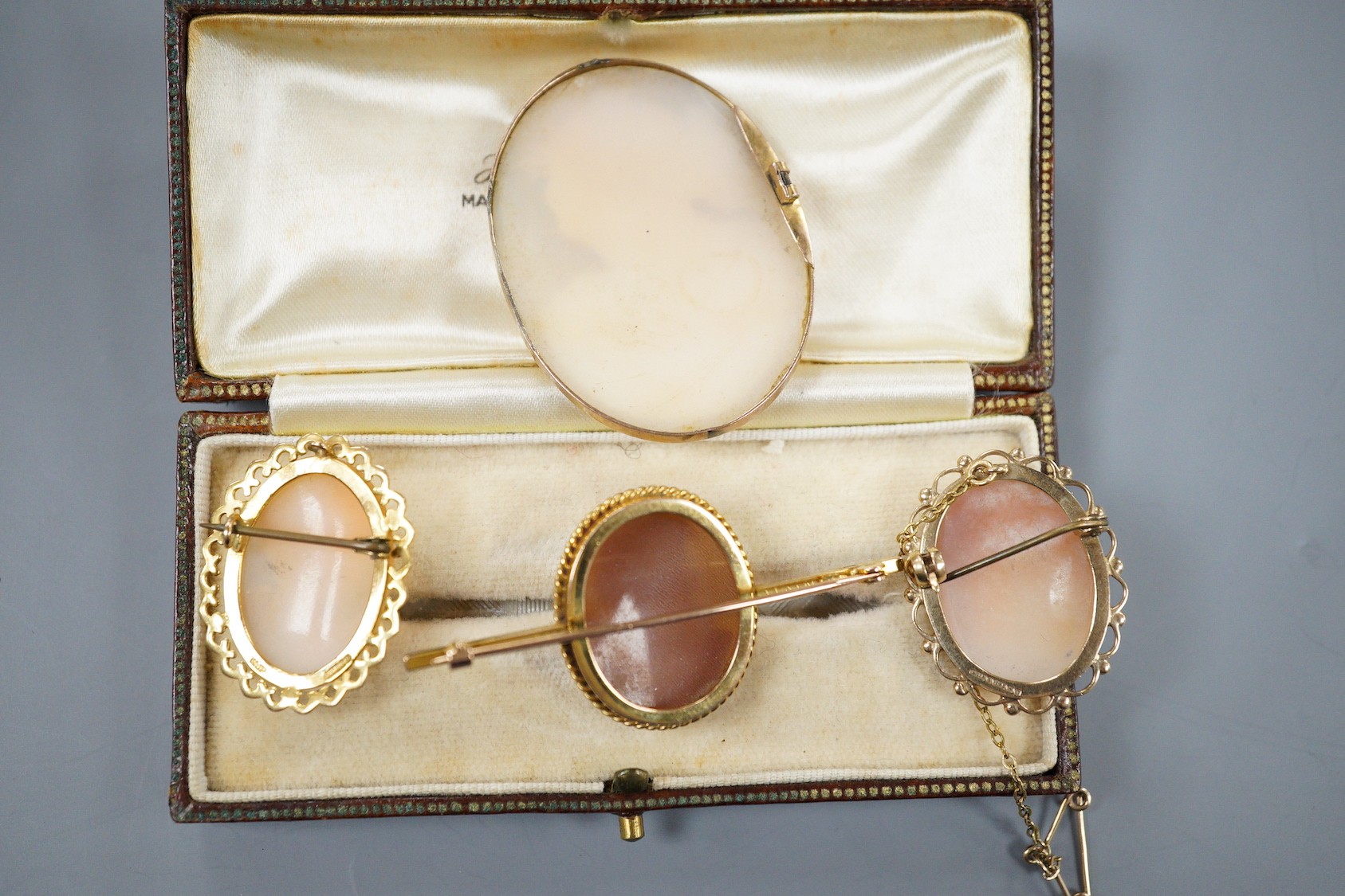 Two modern 9ct gold mounted oval cameo shell brooches, largest 30mm, a 9ct and oval cameo shell set bar brooch and one other yellow metal mounted cameo brooch(lacking pin).